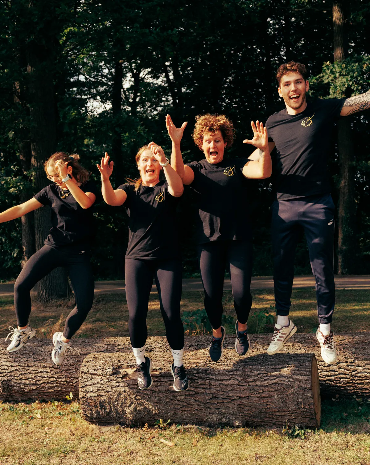Het team van LevelFit springt samen van een boomstam in het Twekkelose bos